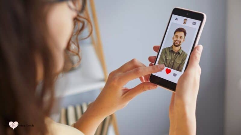 woman holding phone and looking at online dating profile.