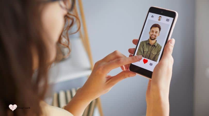 woman holding phone and looking at online dating profile.