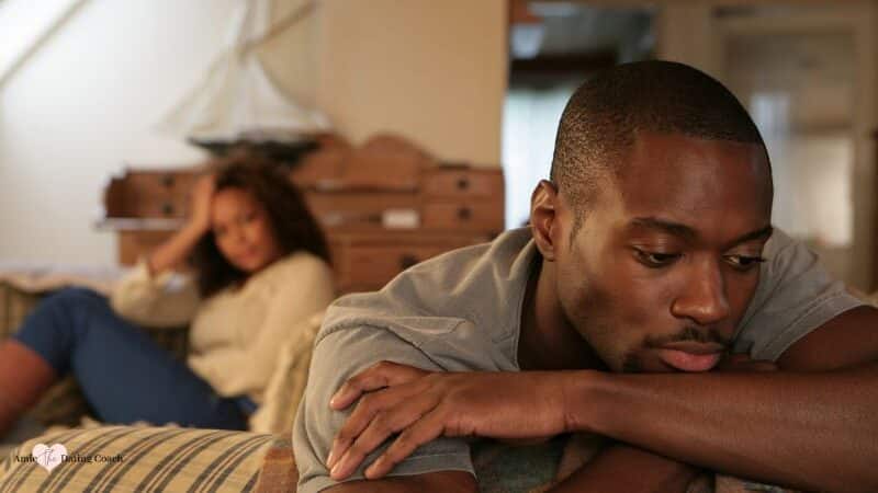 couple not talking to each other sitting apart on couch