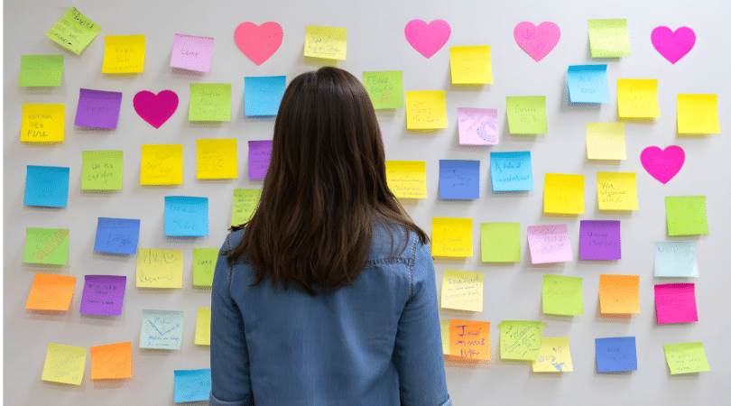 Woman staring at a wall with post it notes