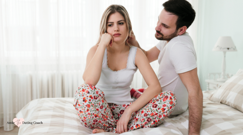 woman sitting unhappy on bed and man sitting next to her