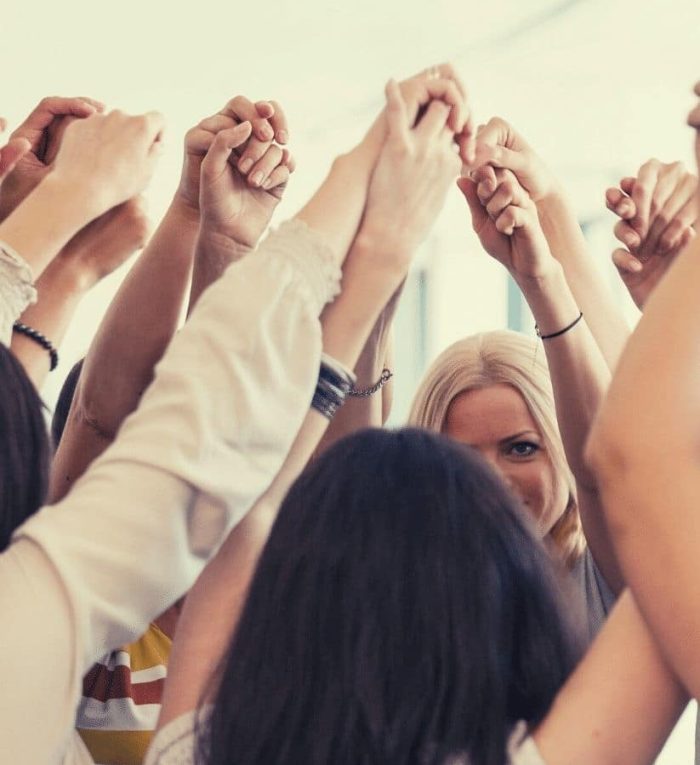 group coaching women holding hands